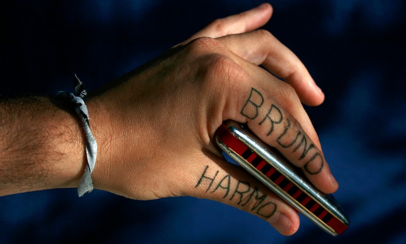 Main de Bruno Harmo, harmoniciste professionnel et professeur d'harmonica, tenant un harmonica Golden Melody.Sur sa main il a noté son nom d'artiste bruno harmo au stylo bille pour le fun