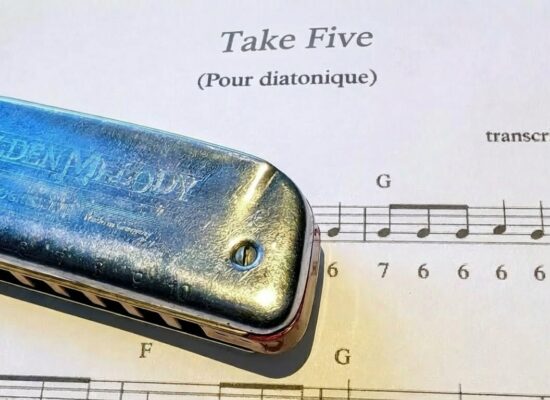 "Partition de Take Five pour harmonica diatonique avec un harmonica posé dessus"
